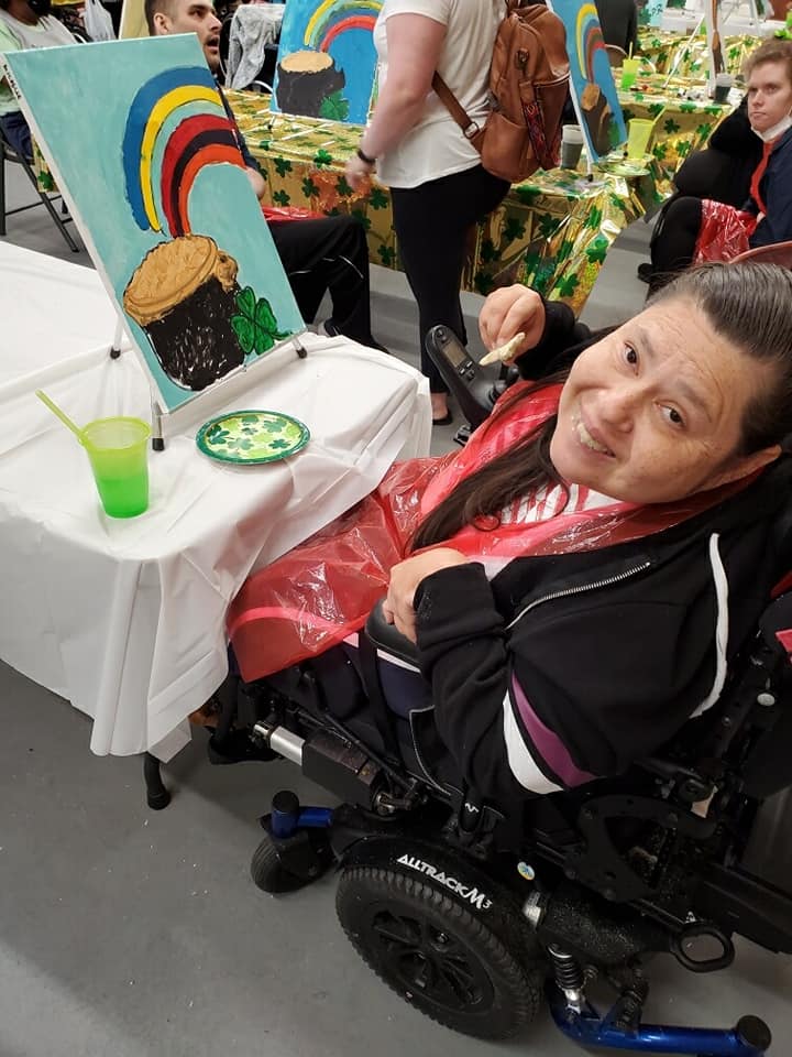 woman painting a pot of gold and a rainbow