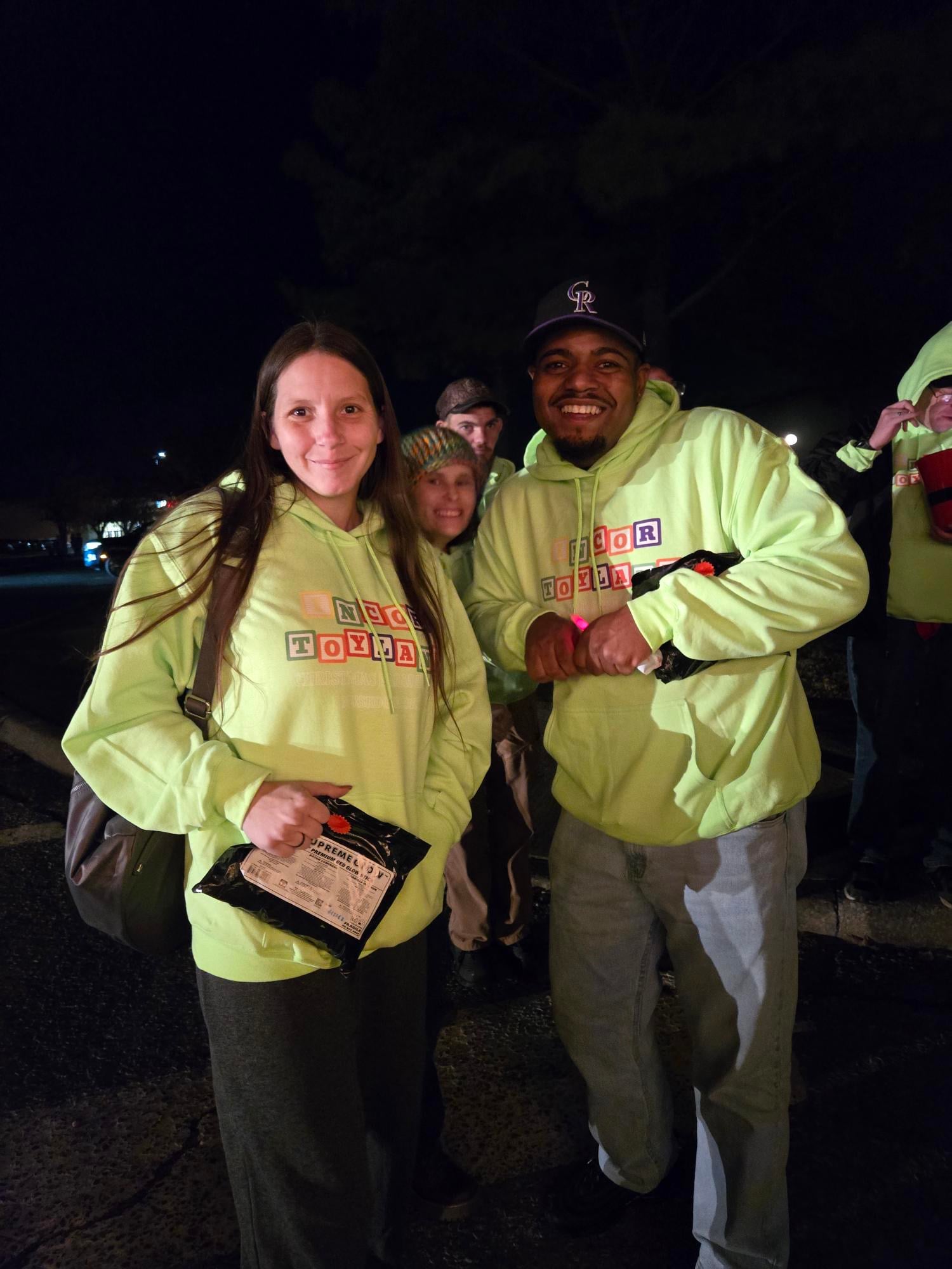 people wearing lime green hoodies at night smiling