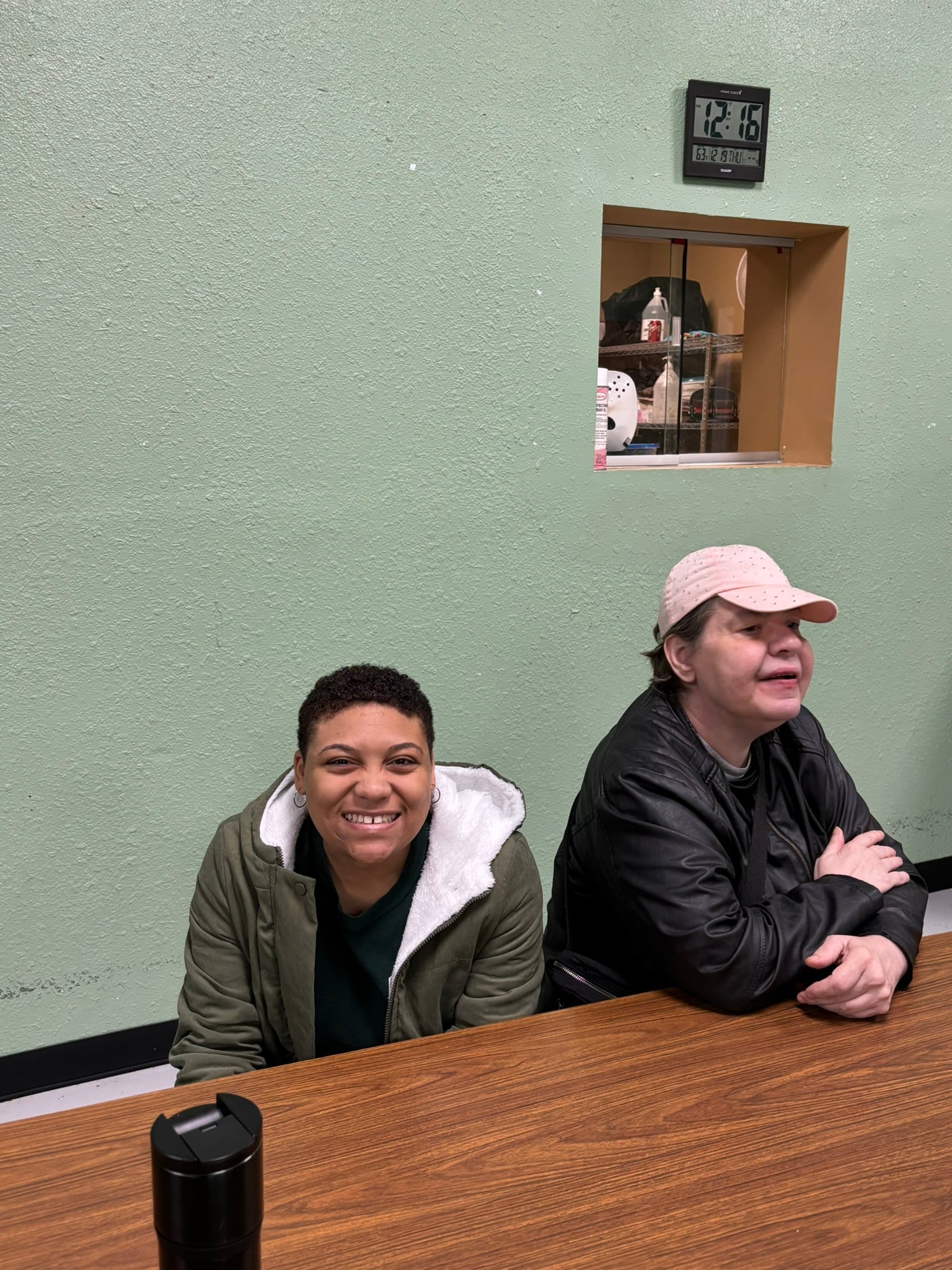 two ladies smiling sitting at a table
