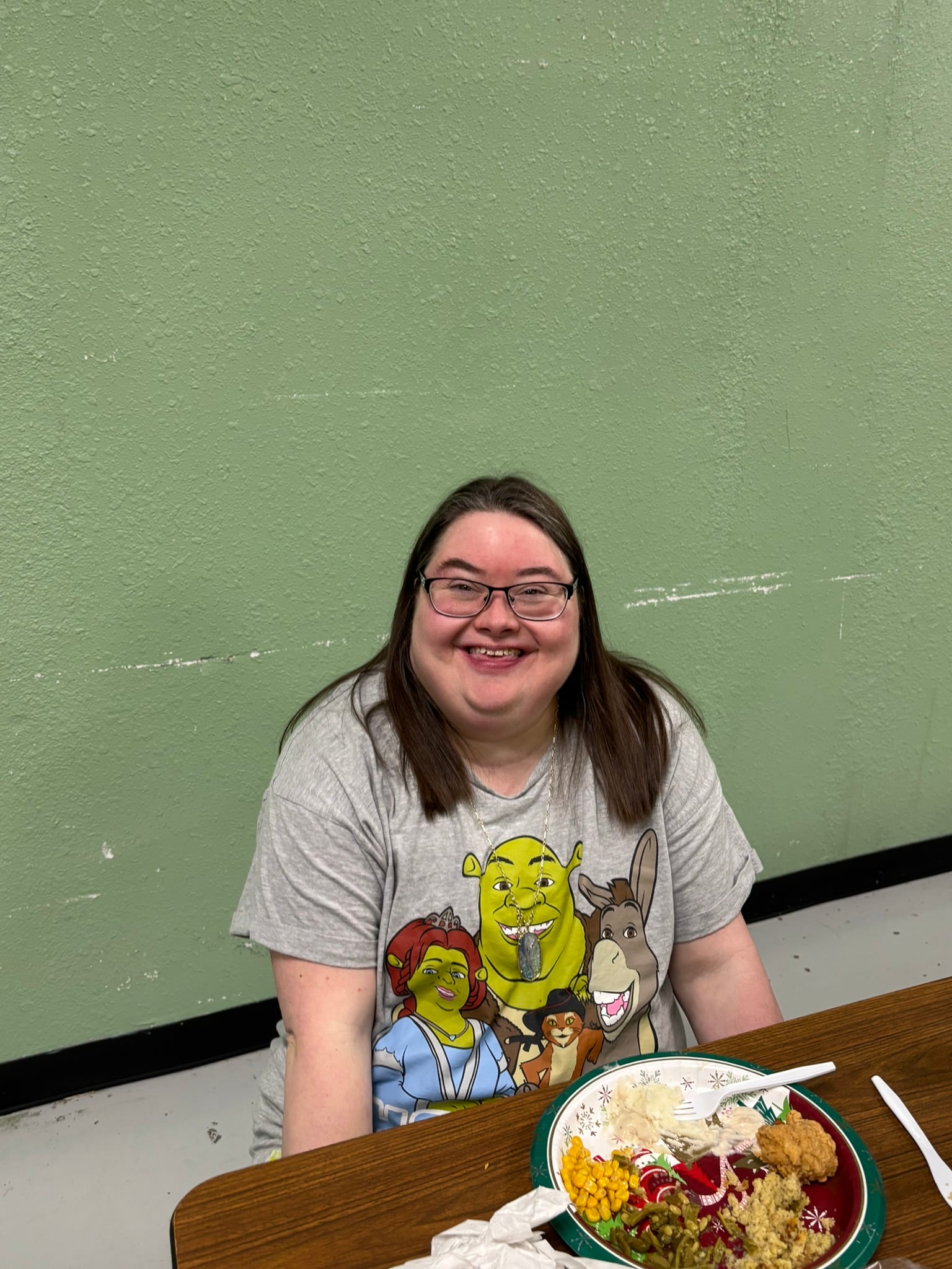 woman smiling sitting at a table eating food