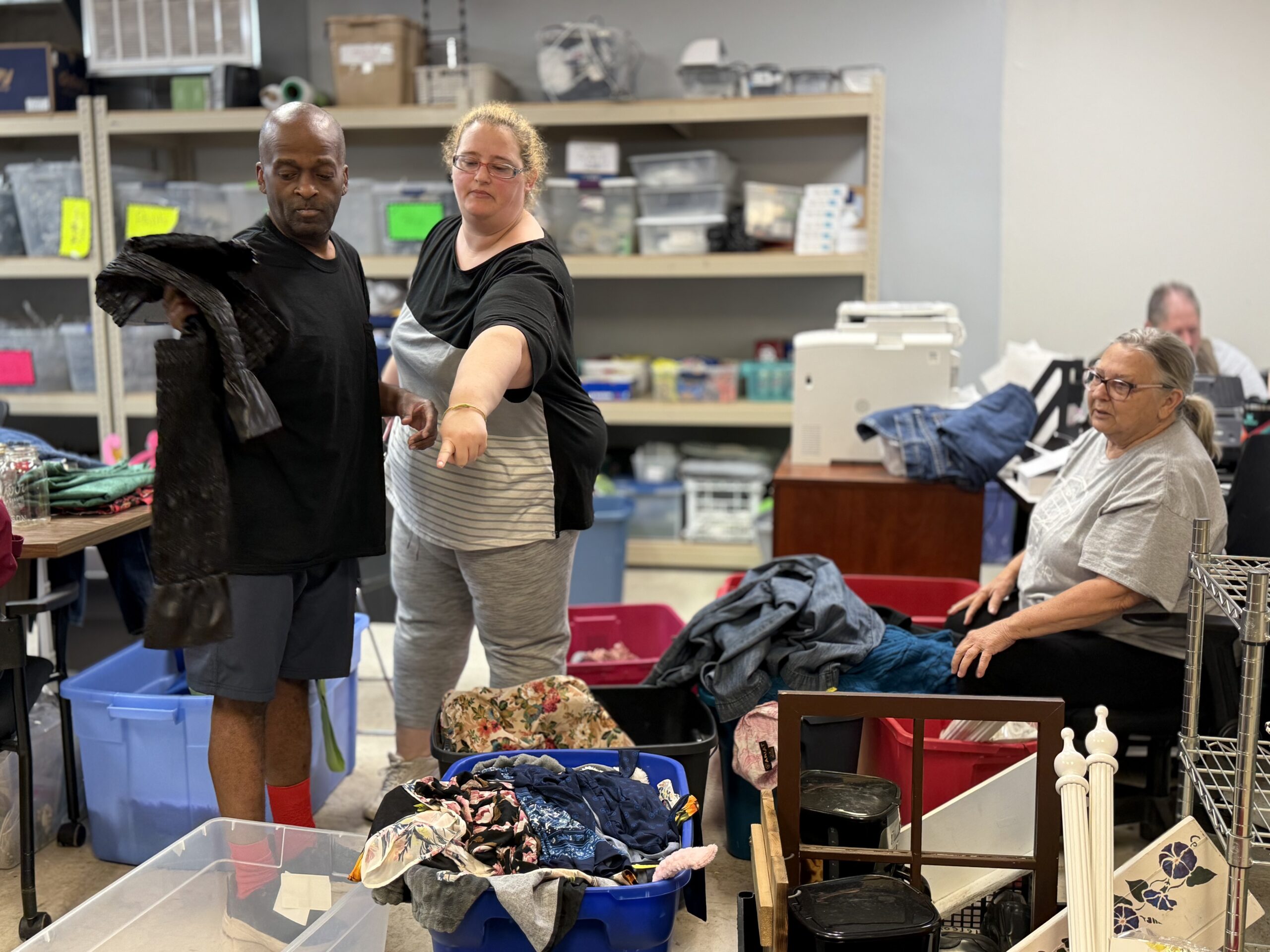 group of people dividing clothes into bins