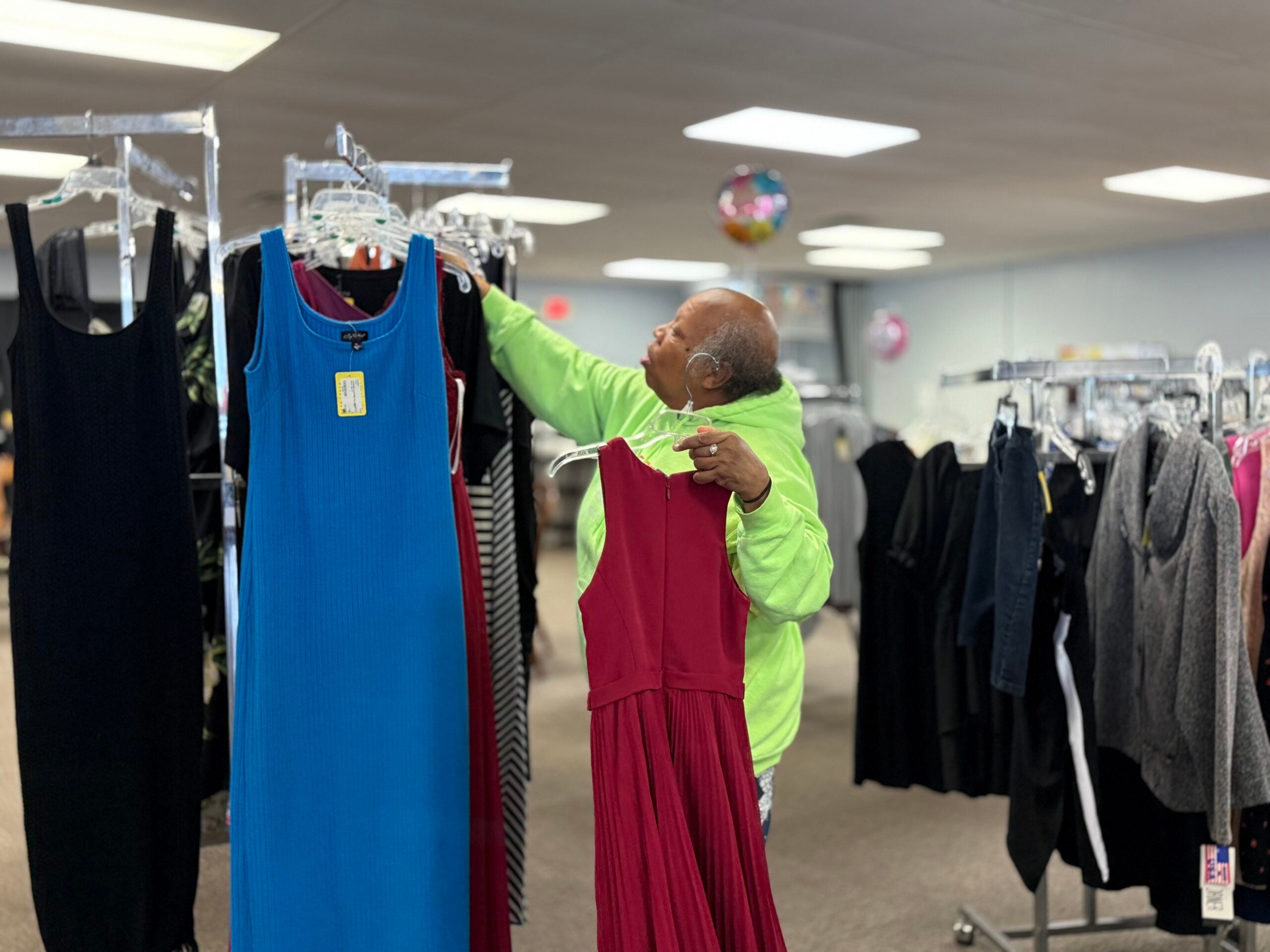 woman hanging clothes on a rack in a store